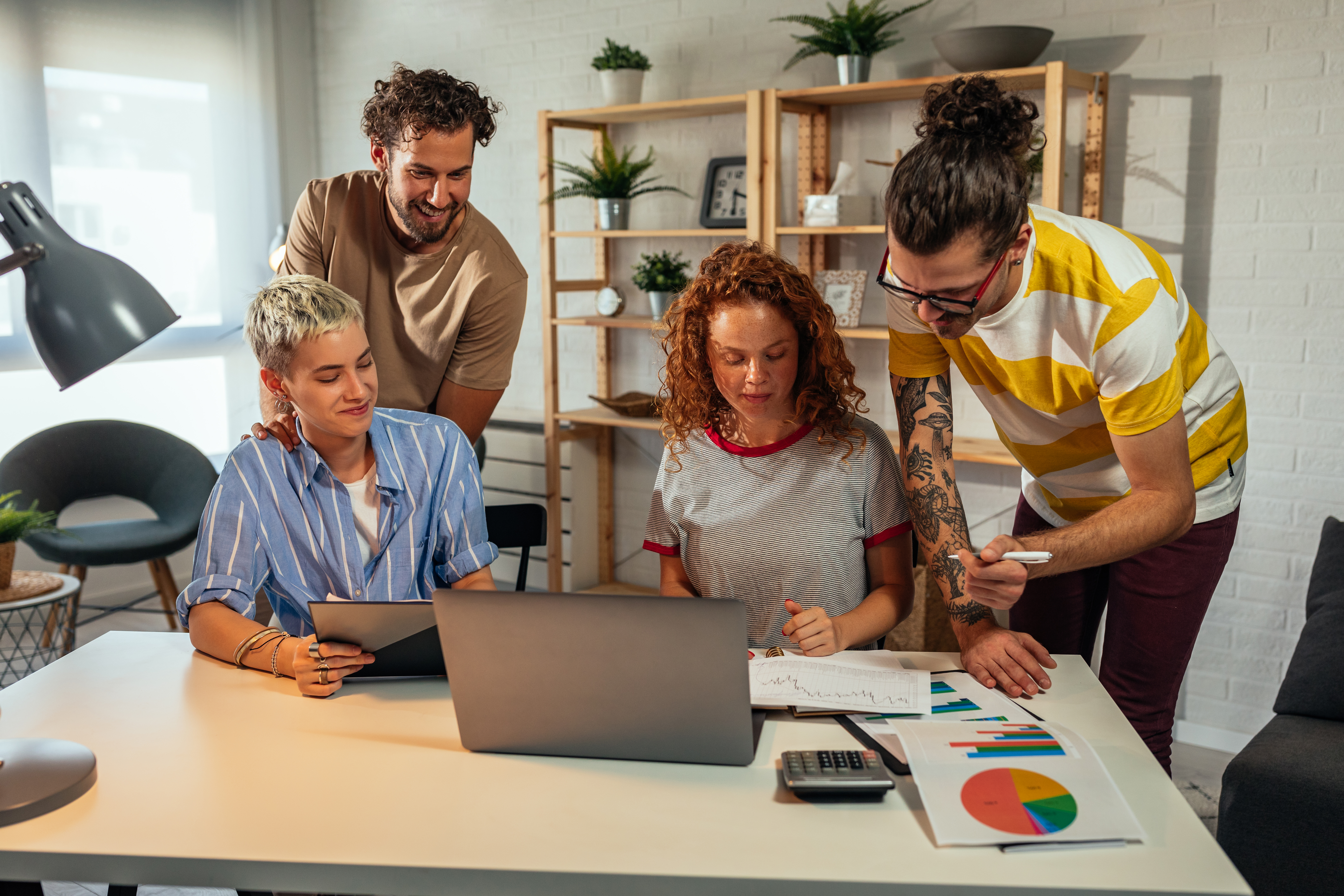 Creative team collaborating around a laptop
